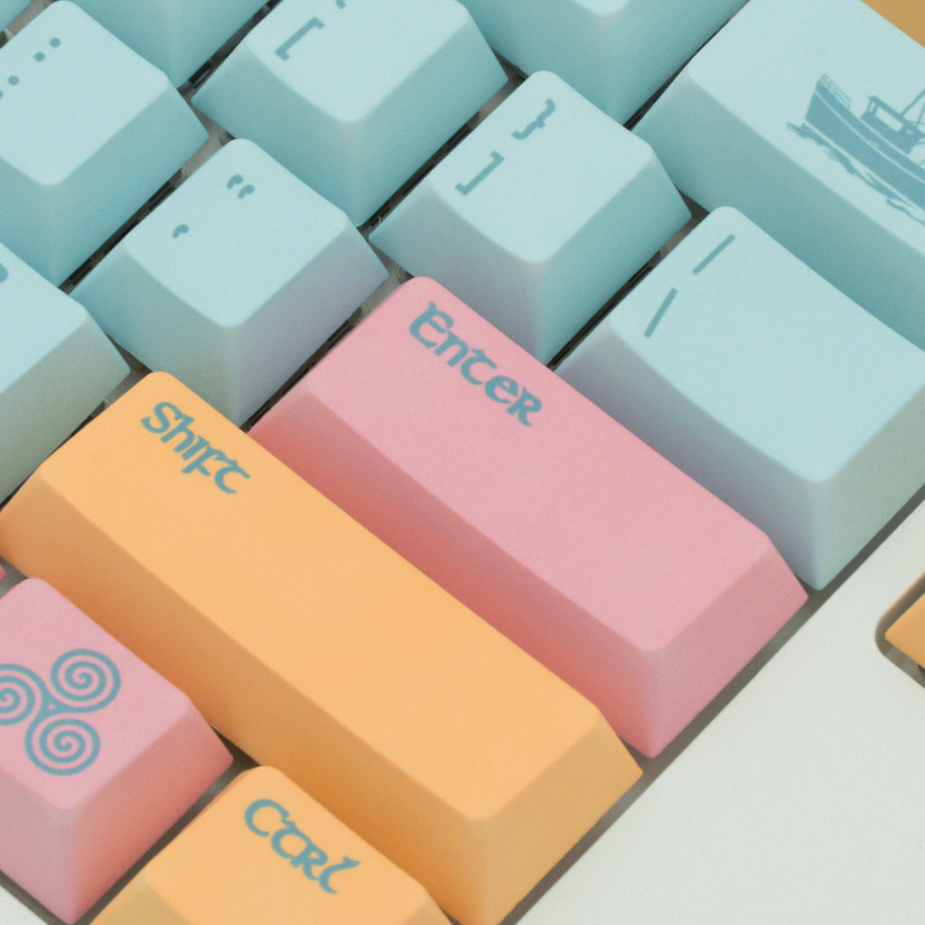 Portree keycaps inspired by the harbor town of Portree, featuring rich blues and pinks and yellows of the iconic downtown harbor buildings. Close up view.